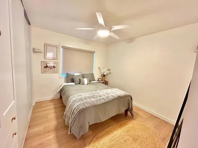 a bedroom with a bed and painting on the wall