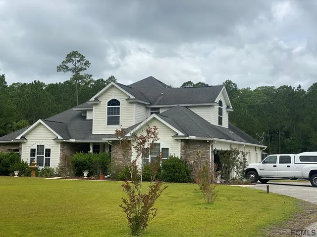 a front view of a house with a garden and yard