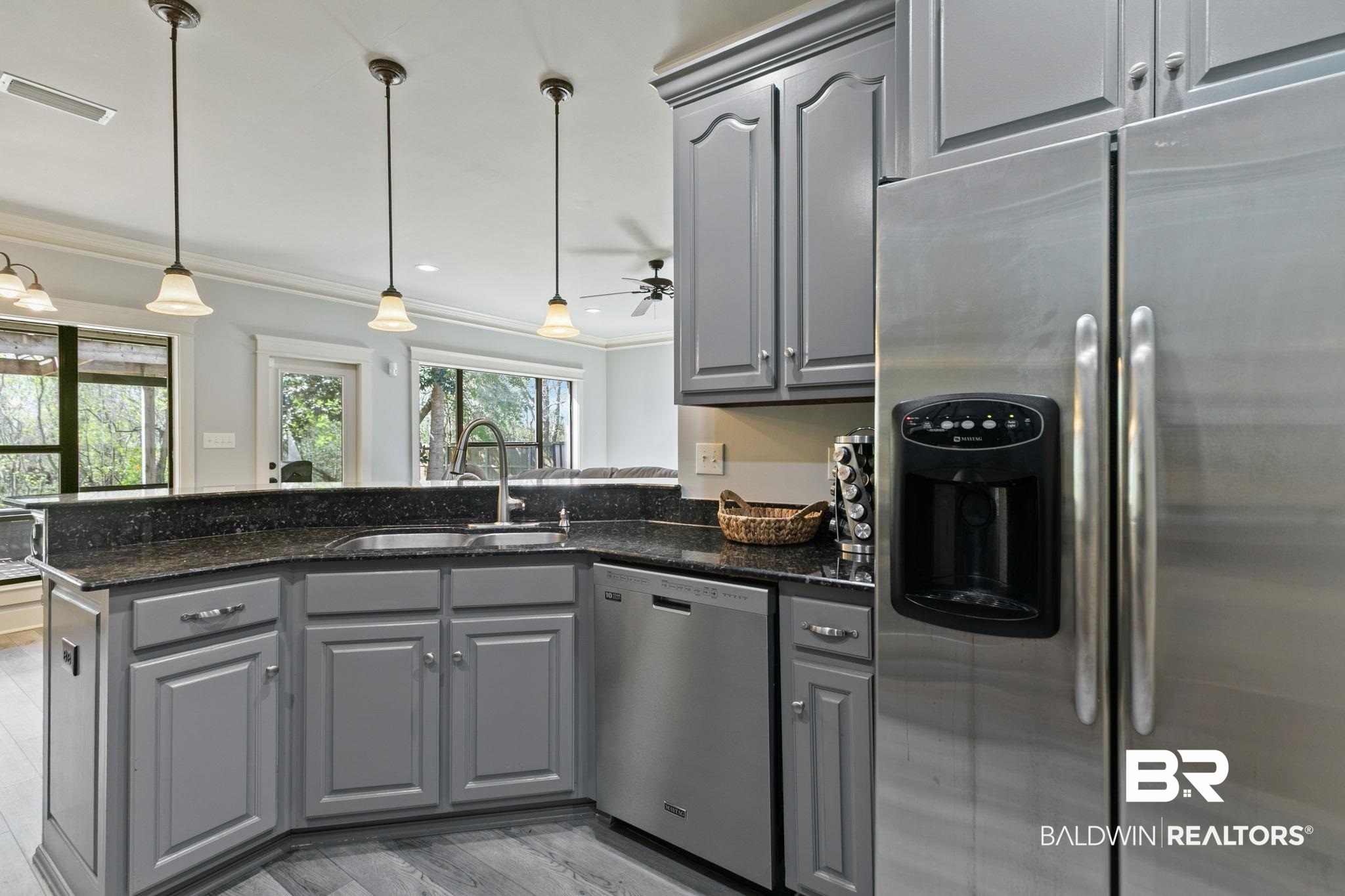 9584 Sanibel Loop Daphne, AL 36526 - Photo 16 of 48 Kitchen with gray cabinets, stainless steel appliances, crown molding, hanging light fixtures, and dark stone countertops
