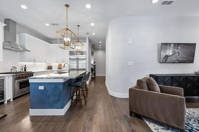 a living room with stainless steel appliances kitchen island a table and chairs