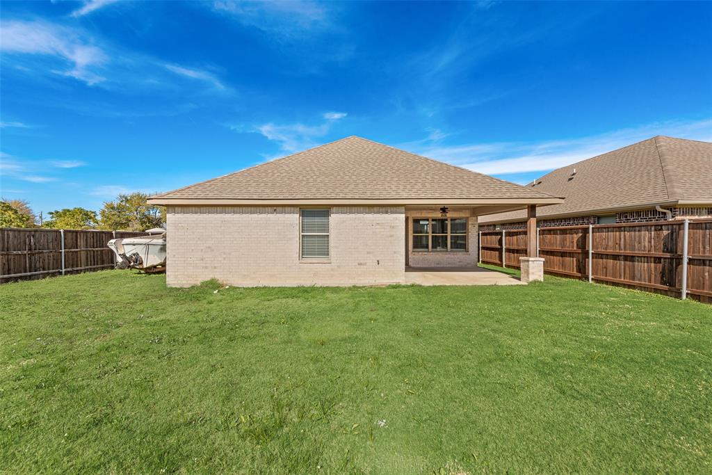 625 Copenhavr Street Pilot Point, TX 76258 - Photo 20 of 20 Back of property with a patio area, roof with shingles, brick siding, and a fenced backyard