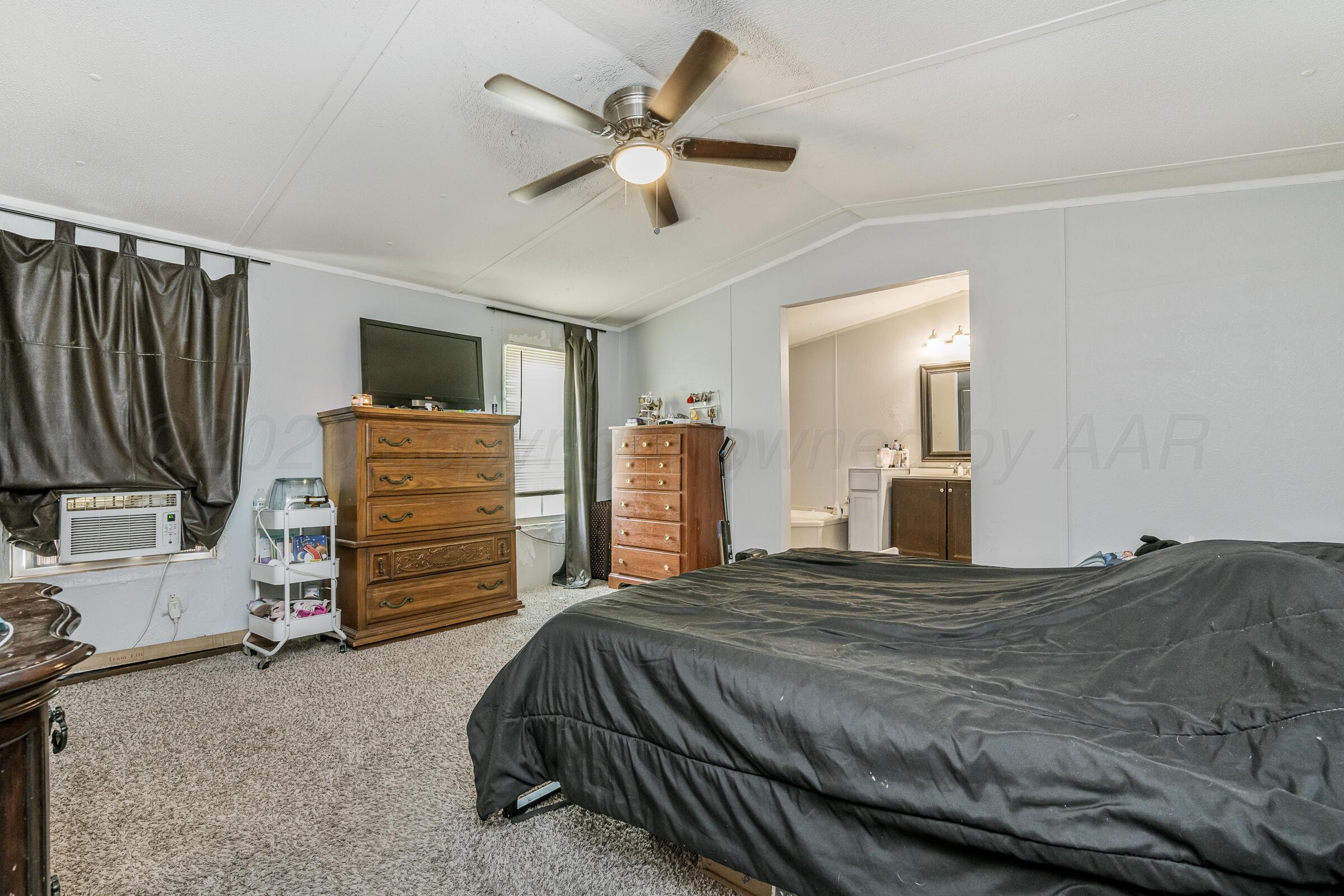 2115 Country Lane Amarillo, TX 79118 - Photo 11 of 15 a bedroom with a bed dresser and flat screen tv