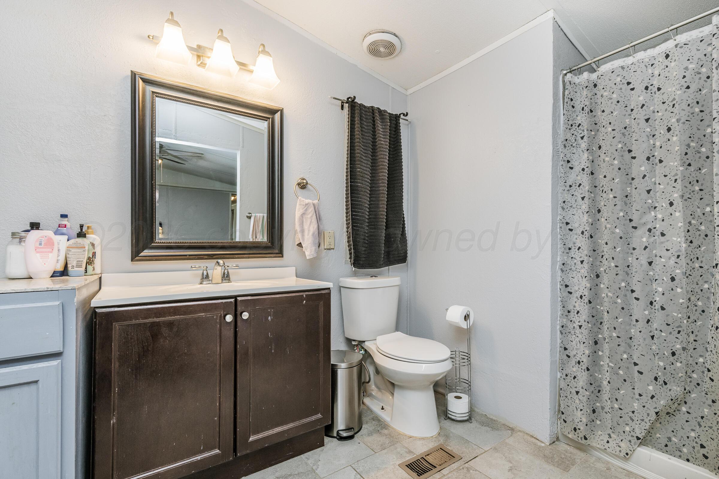 2115 Country Lane Amarillo, TX 79118 - Photo 13 of 15 a bathroom with a toilet sink and mirror