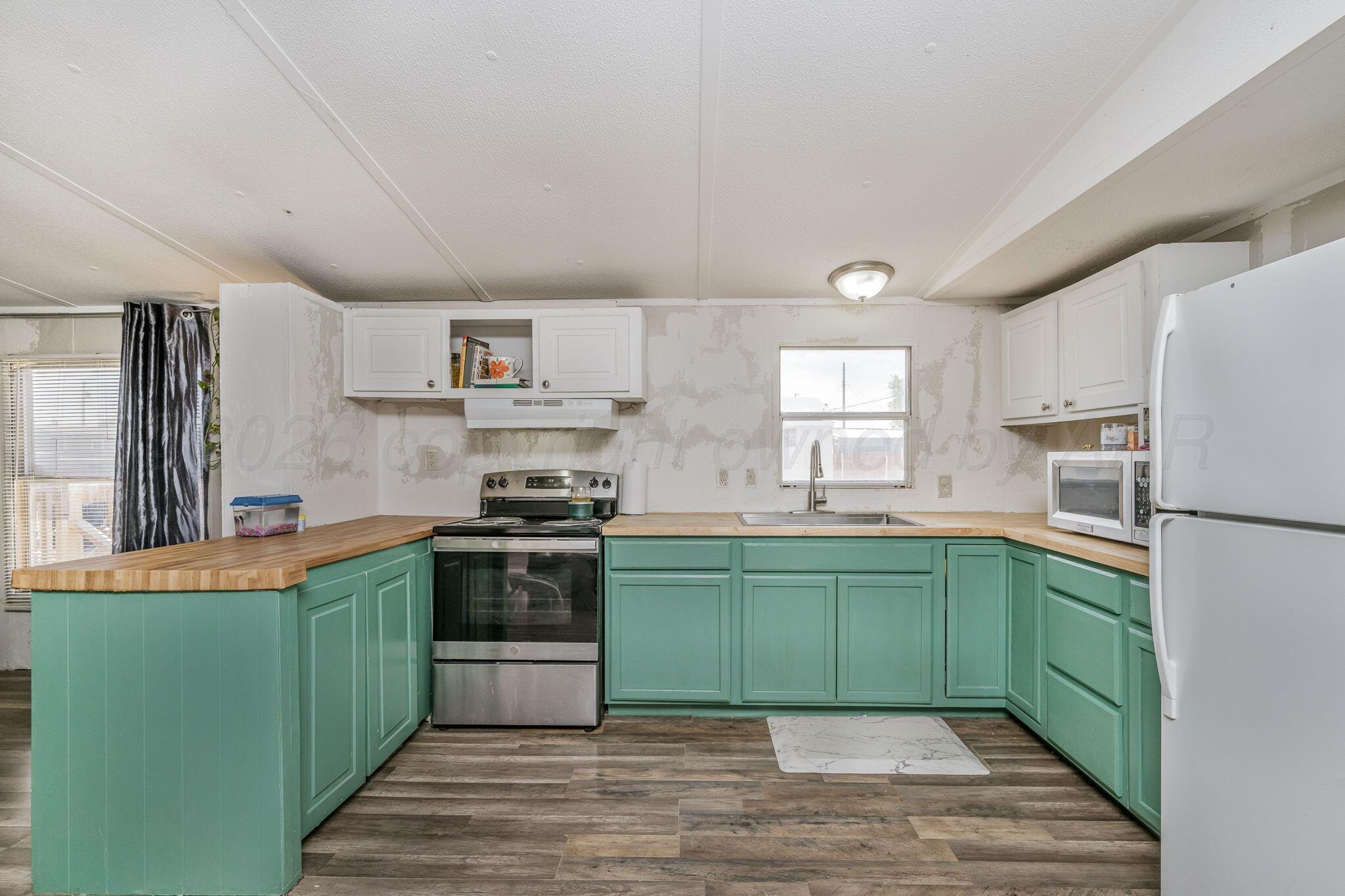 2115 Country Lane Amarillo, TX 79118 - Photo 2 of 15 a kitchen with stainless steel appliances granite countertop a sink and a stove top oven