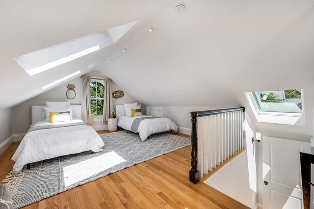 a spacious bedroom with two beds and painting on the wall