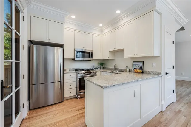 a kitchen with stainless steel appliances granite countertop a refrigerator stove microwave and sink