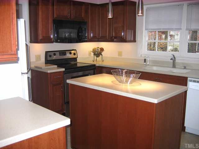 1421 Bridgeport Drive Raleigh, NC 27615 - Photo 3 of 10 a kitchen with stainless steel appliances a sink a stove a refrigerator cabinets and a window