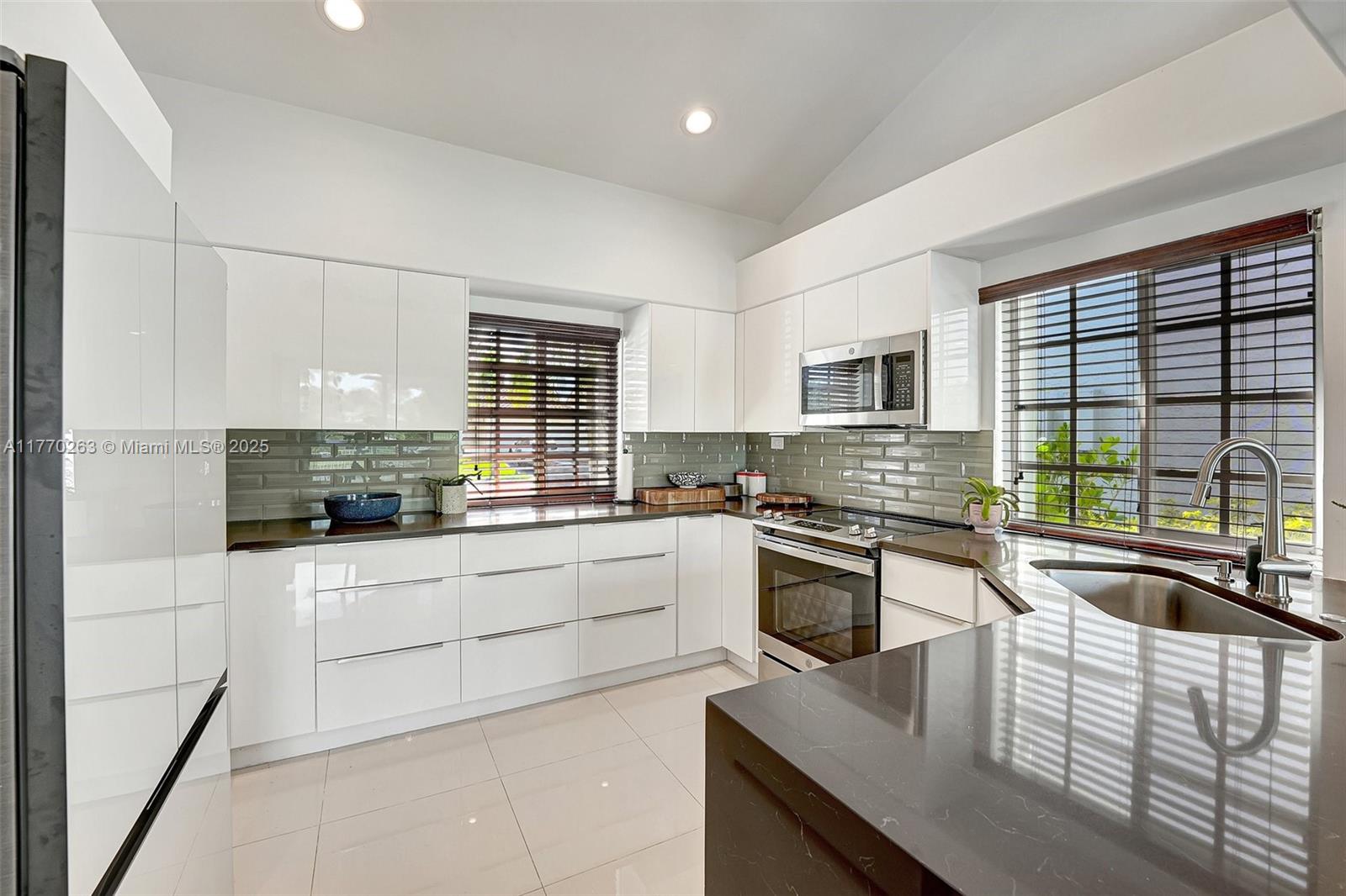 1055 San Luis Rey Weston, FL 33326 - Photo 25 of 75 a kitchen with granite countertop a stove sink and cabinets