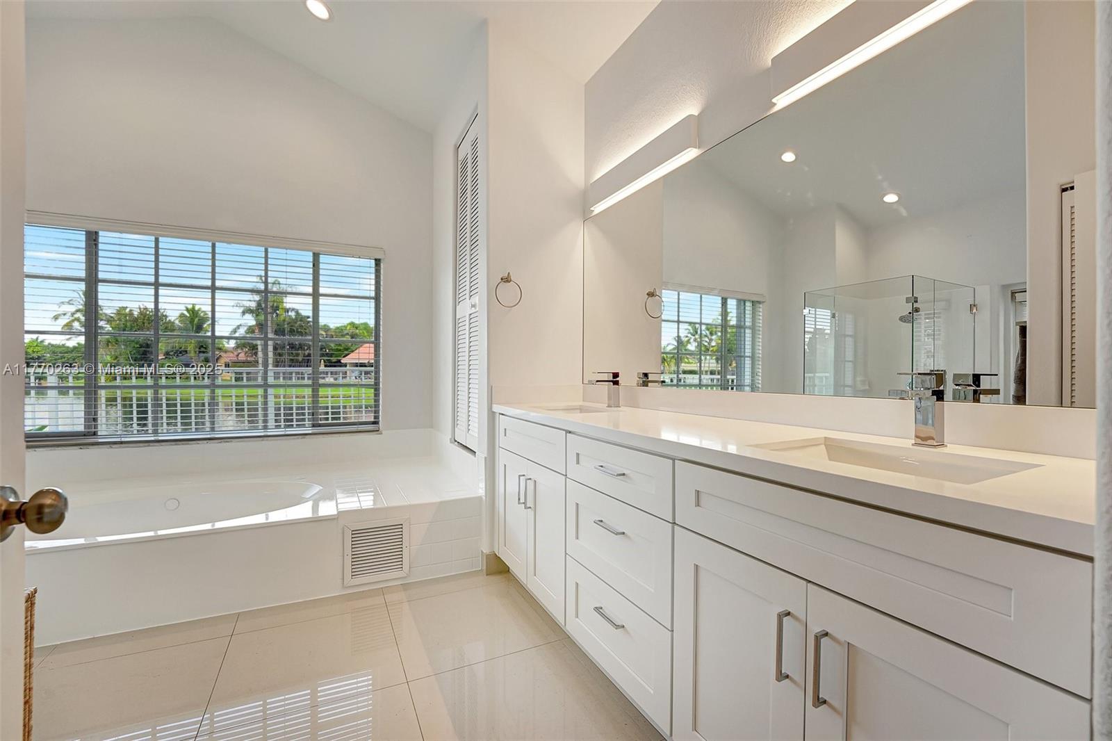 1055 San Luis Rey Weston, FL 33326 - Photo 29 of 75 a spacious bathroom with sinks mirror and a bathtub