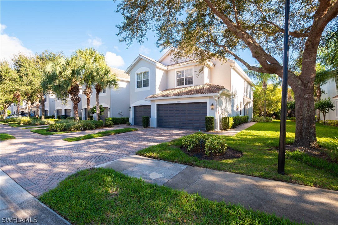15633 Marcello Circle, Unit 133 Naples, FL 34110 - Photo 1 of 23 a front view of a house with a yard and a garden