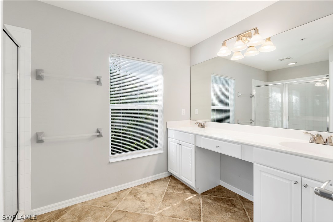 15633 Marcello Circle, Unit 133 Naples, FL 34110 - Photo 15 of 23 a bathroom with a sink double vanity and a mirror