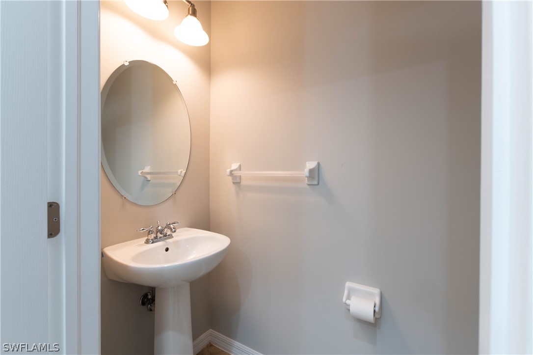 15633 Marcello Circle, Unit 133 Naples, FL 34110 - Photo 6 of 23 a bathroom with a sink and mirror