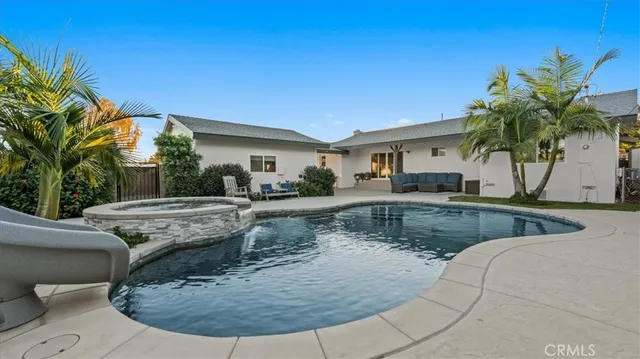 a view of a house with swimming pool and sitting area