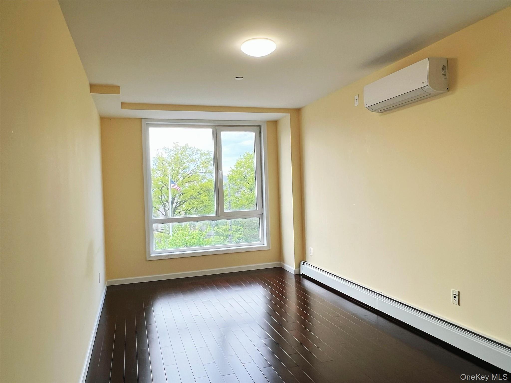 138-12 Northern Boulevard, Unit 6B Queens, NY 11354 - Photo 8 of 10 an empty room with wooden floor and windows