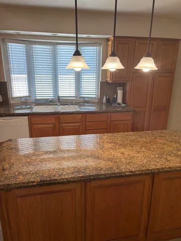 a bathroom with a granite countertop sink and a large window