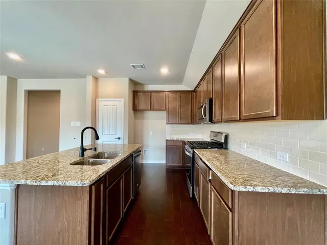 a kitchen with a kitchen island sink stove and refrigerator