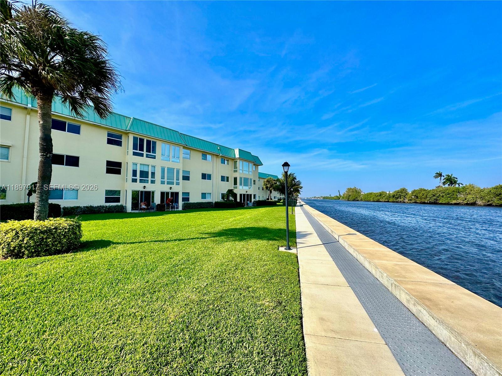 35 Colonial Club Drive, Unit 203 Boynton Beach, FL 33435 - Photo 2 of 29 a view of swimming pool with a garden and trees