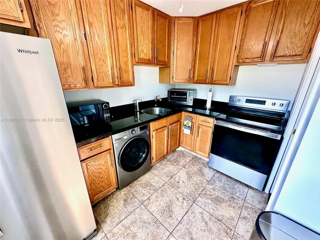 a kitchen with wooden floor and a refrigerator