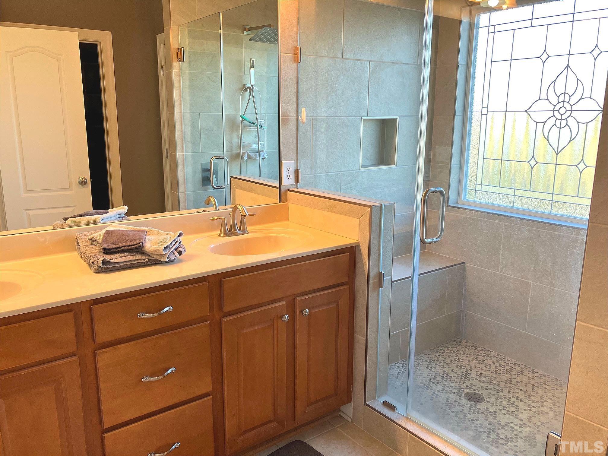 7733 Pegram Street Willow Spring, NC 27592 - Photo 21 of 34 a bathroom with a granite countertop sink a mirror and a shower