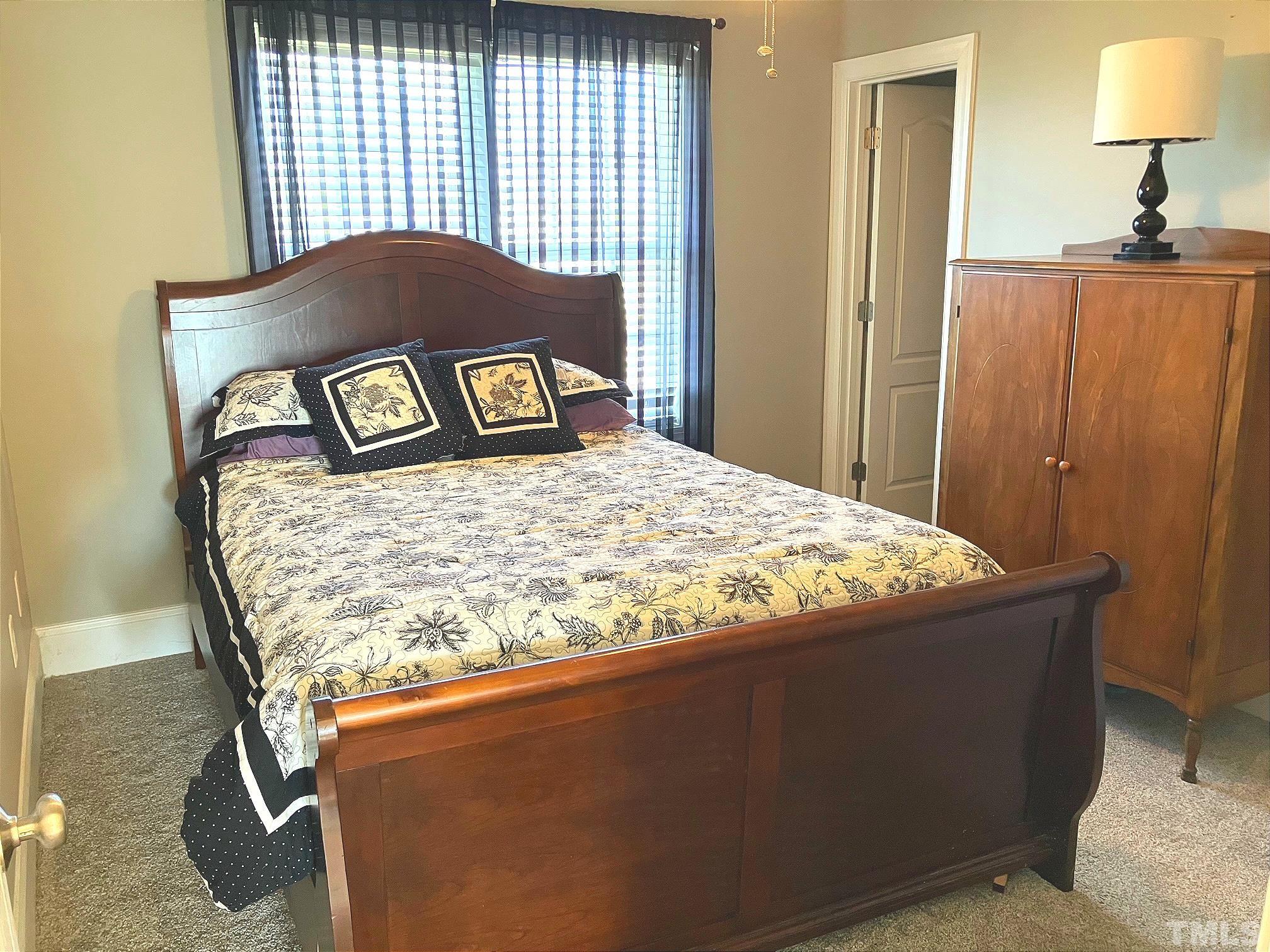 7733 Pegram Street Willow Spring, NC 27592 - Photo 23 of 34 a bed sitting in a bedroom next to a window