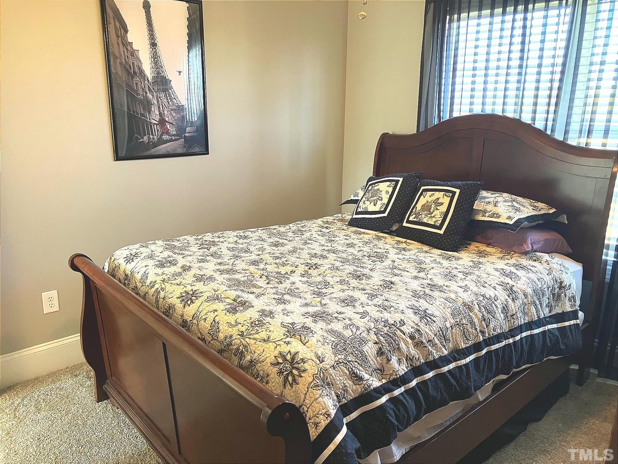 7733 Pegram Street Willow Spring, NC 27592 - Photo 24 of 34 a bed sitting in a bedroom next to a window
