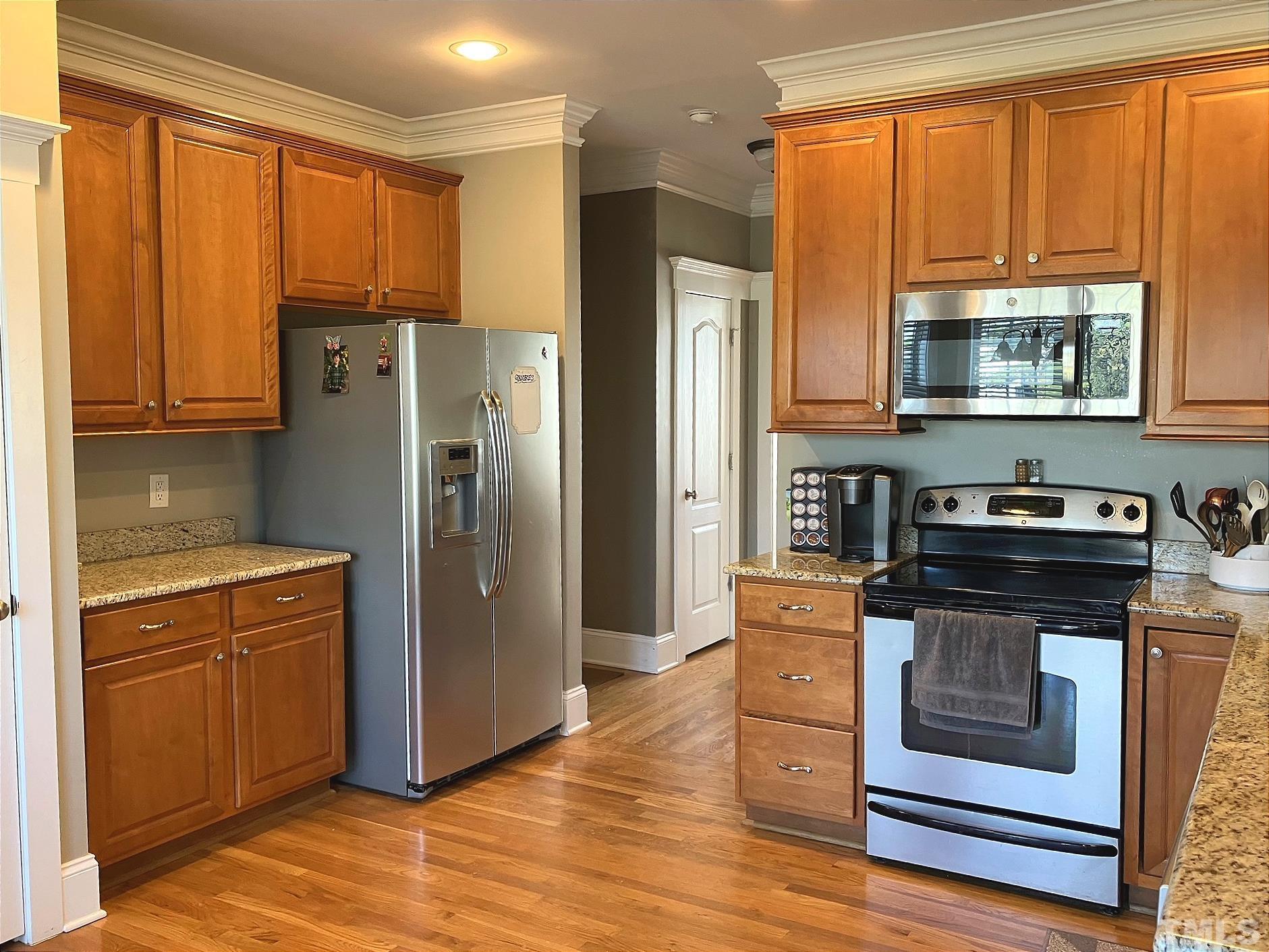 7733 Pegram Street Willow Spring, NC 27592 - Photo 8 of 34 a kitchen with stainless steel appliances granite countertop a refrigerator a stove a sink and a cabinets