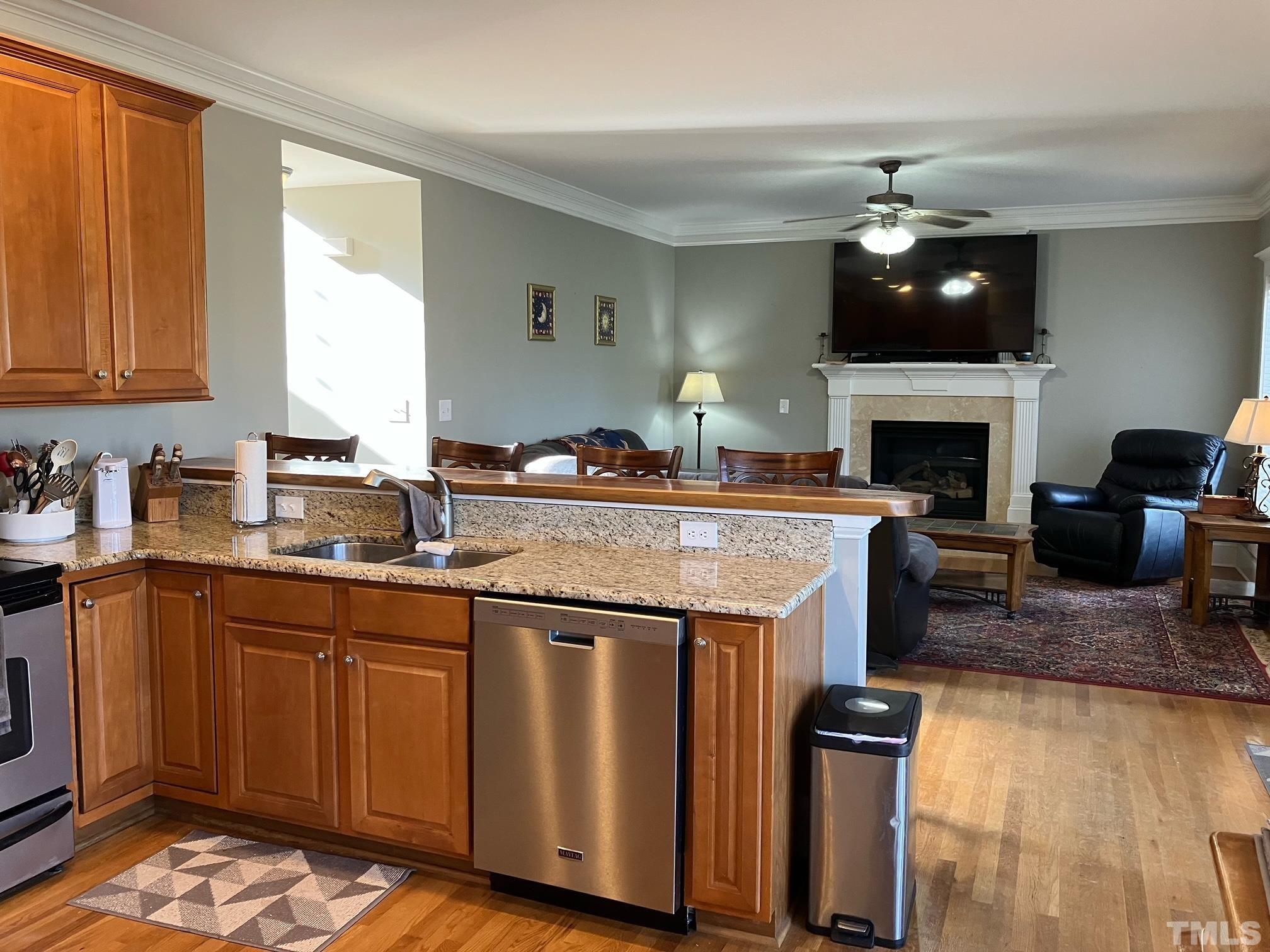 7733 Pegram Street Willow Spring, NC 27592 - Photo 10 of 34 a open kitchen with granite countertop a sink dishwasher stove and cabinets