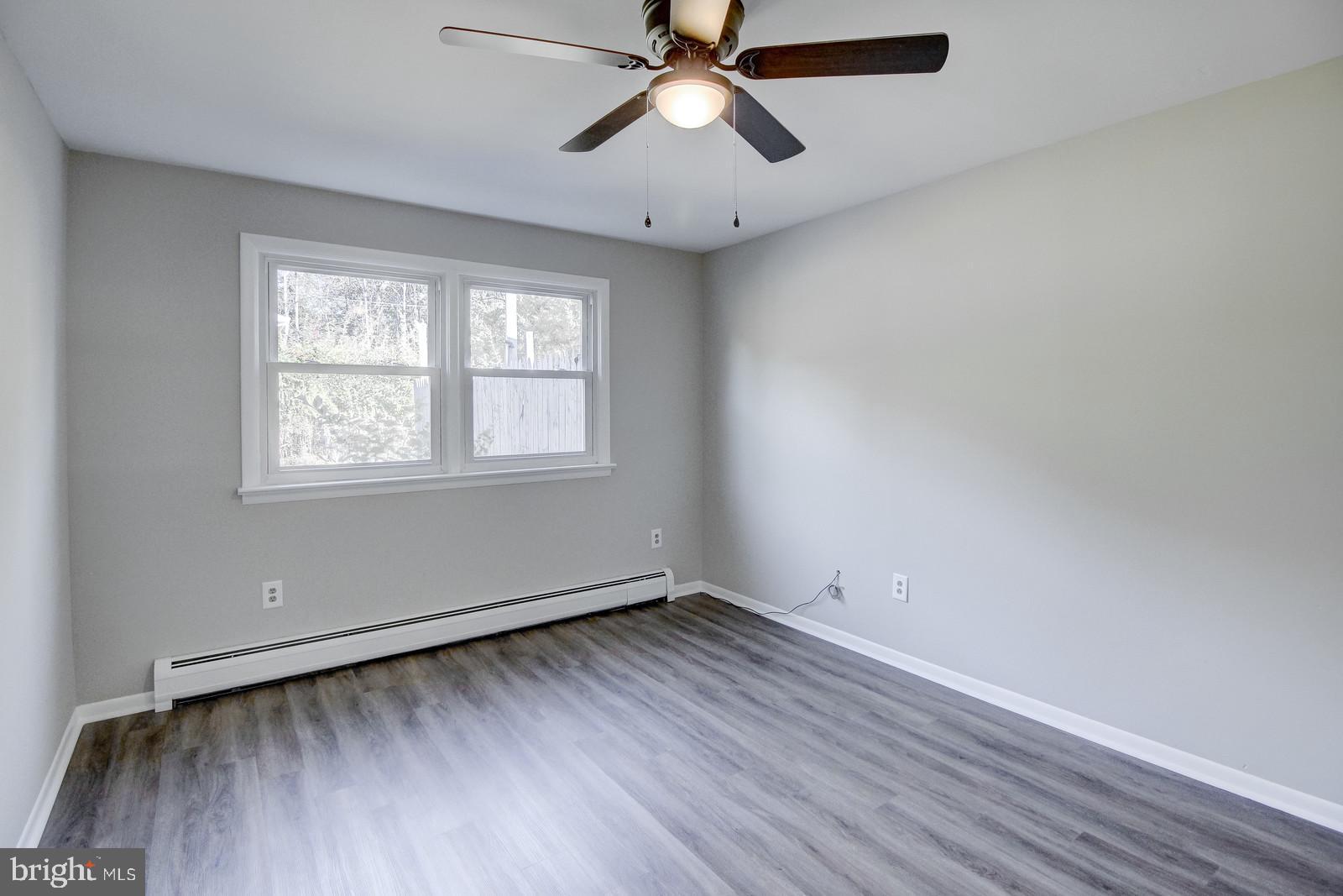 331 Juliustown Road Columbus, NJ 08022 - Photo 18 of 26 an empty room with wooden floor windows and fan