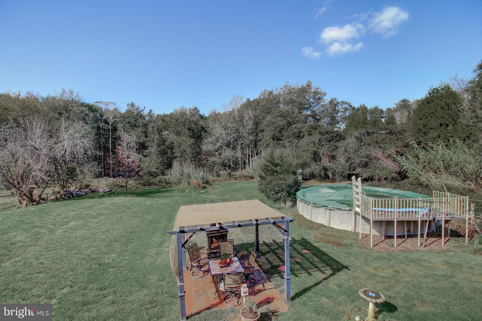 331 Juliustown Road Columbus, NJ 08022 - Photo 23 of 26 a view of a patio with table and chairs under an umbrella next to a yard