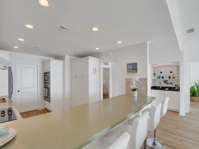 a large living room with stainless steel appliances furniture a refrigerator and a kitchen view