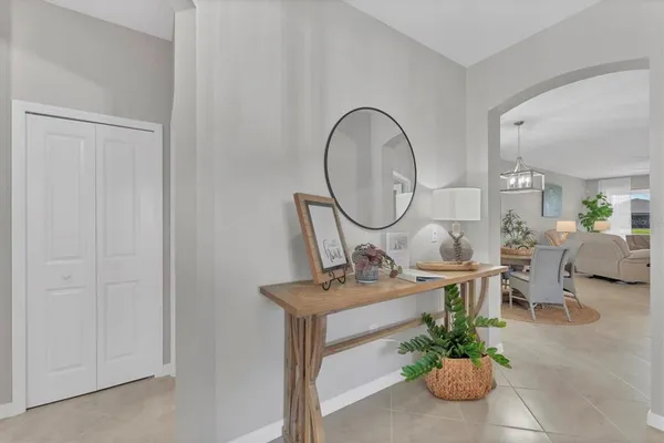 a living room with furniture a mirror and a potted plant