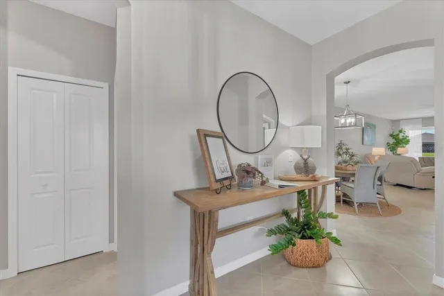 a living room with furniture a mirror and a potted plant
