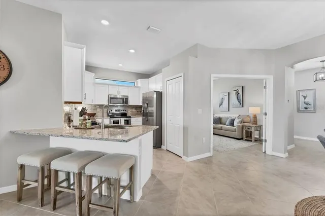a kitchen with stainless steel appliances granite countertop a refrigerator and a sink