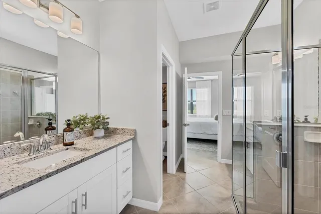 a bathroom with a granite countertop sink mirror and shower