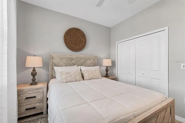 a bedroom with a bed and a lamp on dresser