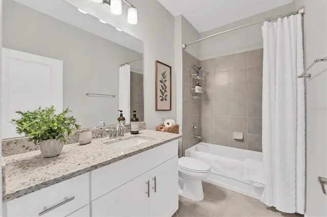 a bathroom with a granite countertop sink a toilet and shower