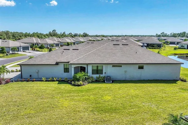 an aerial view of a house with yard and swimming pool