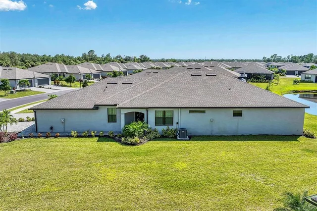 an aerial view of a house with yard and swimming pool