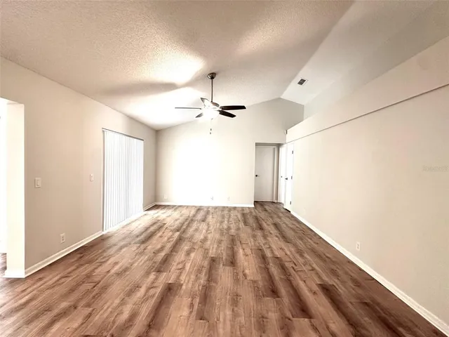 a view of empty room with wooden floor
