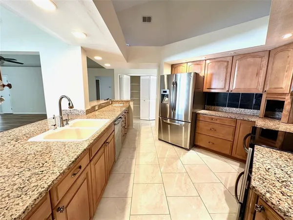 a large kitchen with kitchen island granite countertop a large counter top appliances and cabinets