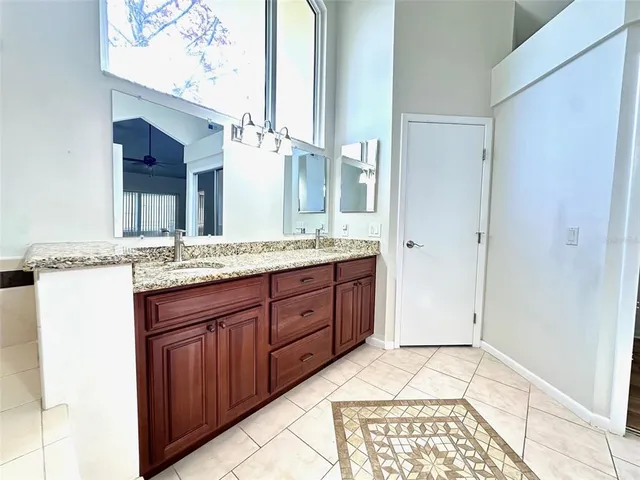 a bathroom with a granite countertop sink and a mirror