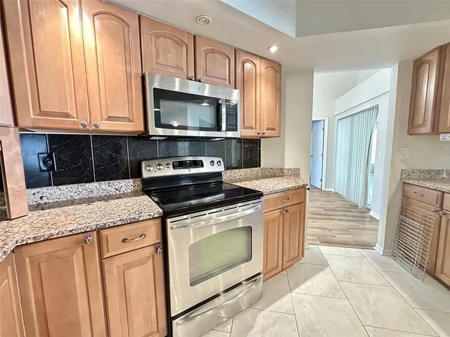 a kitchen with stainless steel appliances granite countertop a stove a sink and a microwave
