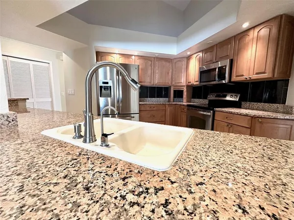 a kitchen with stainless steel appliances kitchen island granite countertop a sink and cabinets