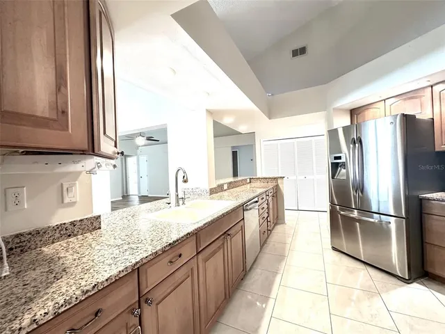 a kitchen with granite countertop a refrigerator and a sink