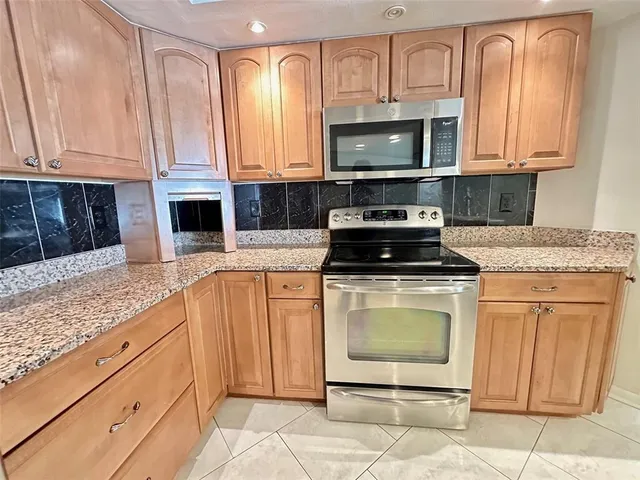 a kitchen with granite countertop white cabinets stainless steel appliances and a sink