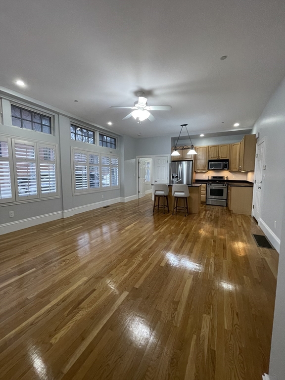 486 Shawmut Avenue, Unit 1 Boston, MA 02118 - Photo 9 of 11 a living room with stainless steel appliances with kitchen view and wooden floor