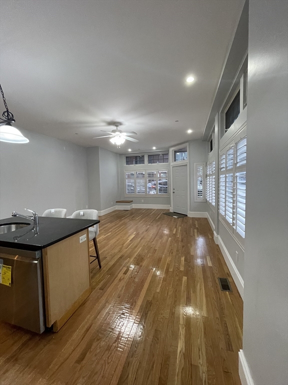 486 Shawmut Avenue, Unit 1 Boston, MA 02118 - Photo 10 of 11 a view of a kitchen with kitchen island a sink wooden floor and a large window