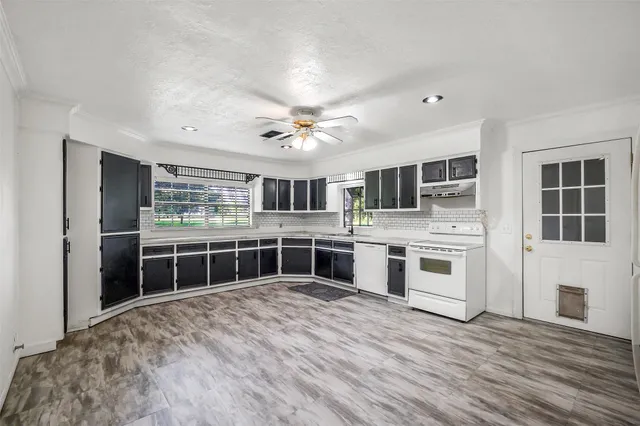 a kitchen with stainless steel appliances a stove top oven and kitchen island