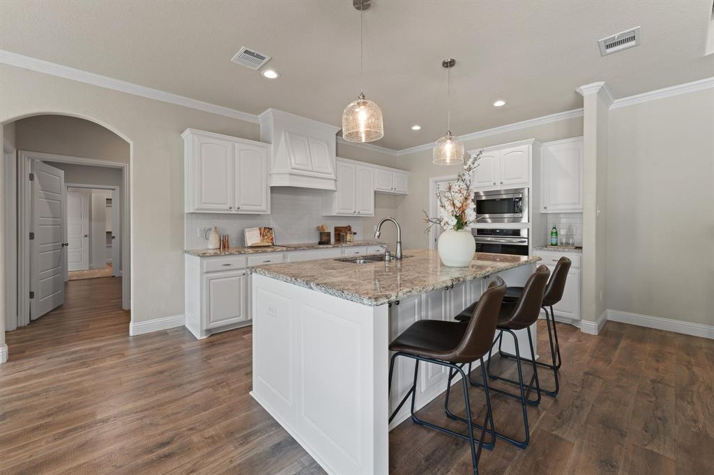 1001 Resolute Road Millsap, TX 76066 - Photo 9 of 40 a kitchen with stainless steel appliances granite countertop a kitchen island a stove a cabinets a sink and a refrigerator