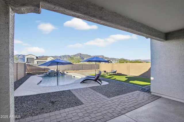 a view of a lake with a table and chairs under an umbrella